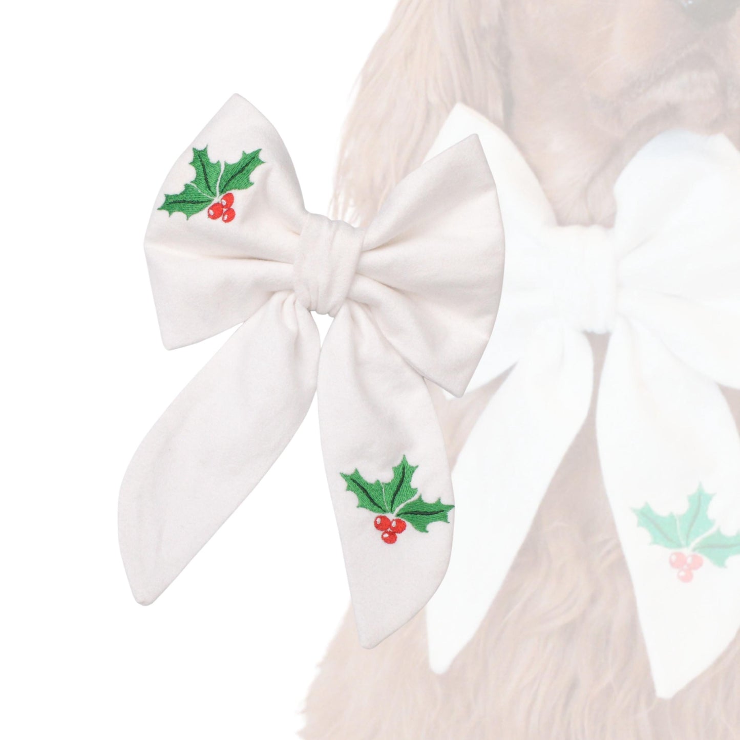 A white bow with green holly leaves and red berries is attached to a dog's fur.