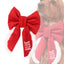 A red bow tie with the word &quot;BLUE&quot; printed on it, attached to a dog&#39;s collar.